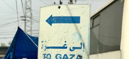 a sign pointing to the right in front of a bus